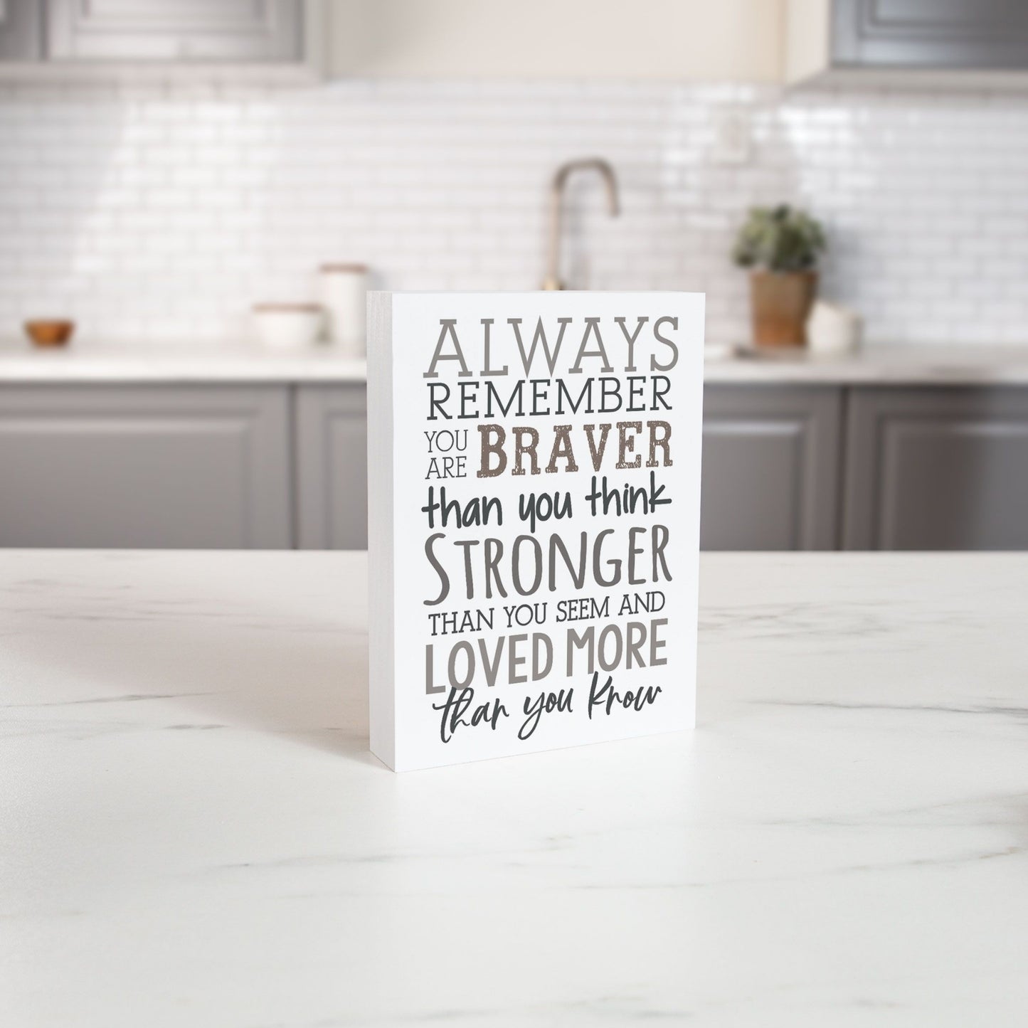 Inspirational Wood Block - Always Remember You are Braver, Stronger, Loved More Than You Know on White Kitchen Counter in front of Grey Kitchen Cabinets | InsideOutCatalog.com