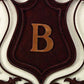 Personalized Wrought Iron Wall Grille - Monogrammed Iron Shield (28.5"W) | Estate Quality Home Decor | Personalized Wall Decor | Shown with the Monogram "B" | Iron finished in a rustic brown gold stain with Italian gold 5" monogram (close up of monogram letter) | INSIDE OUT | InsideOutCatalog.com