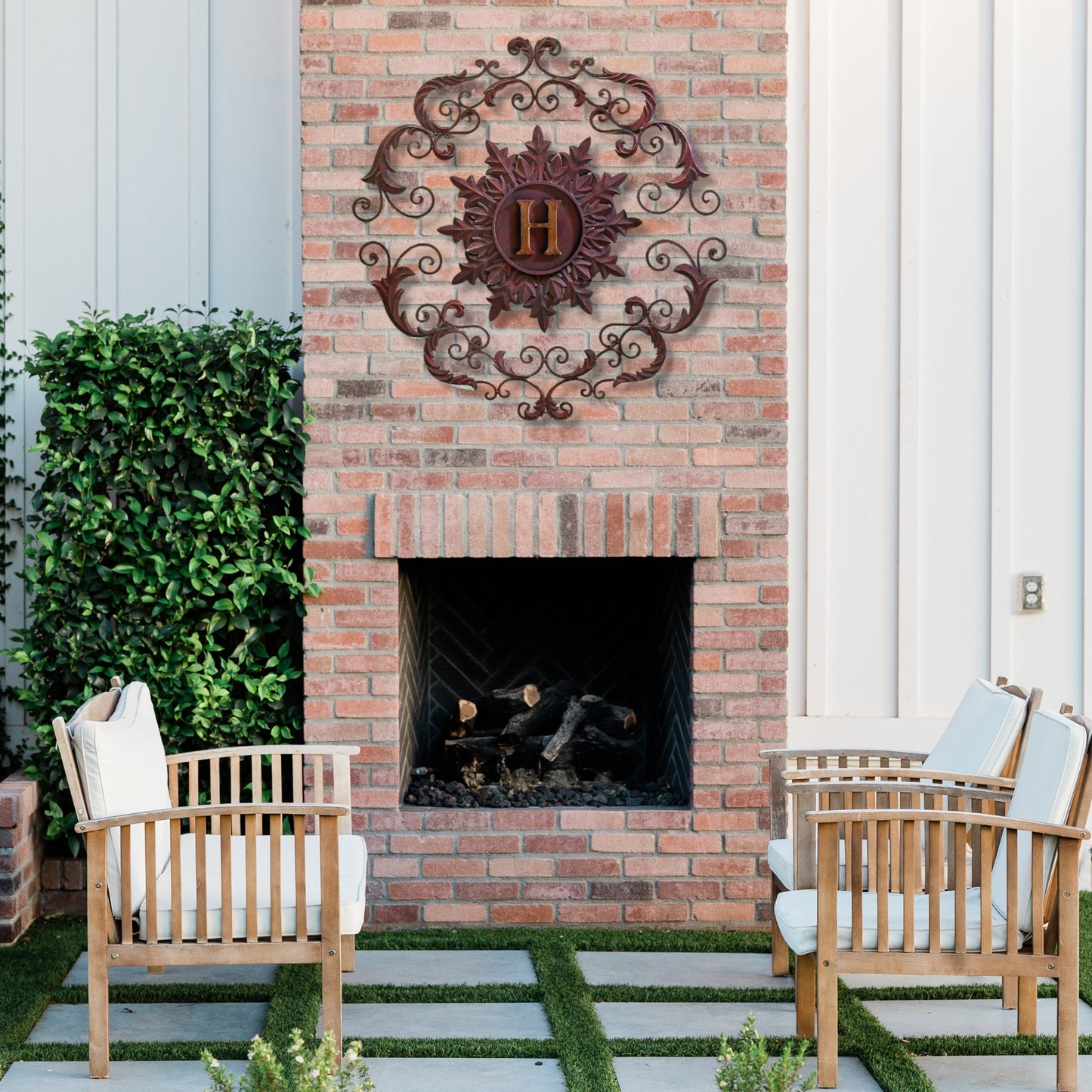 Monogrammed Iron Wall Grille - Monogram Wall Decor | Estate Quality Home Decor | Personalized Wall Decor | Shown with the Monogram "H" | Iron finished in a rustic brown-gold stain with Italian gold 5" monogram shown on covered patio over outdoor brick fireplace | INSIDE OUT | InsideOutCatalog.com