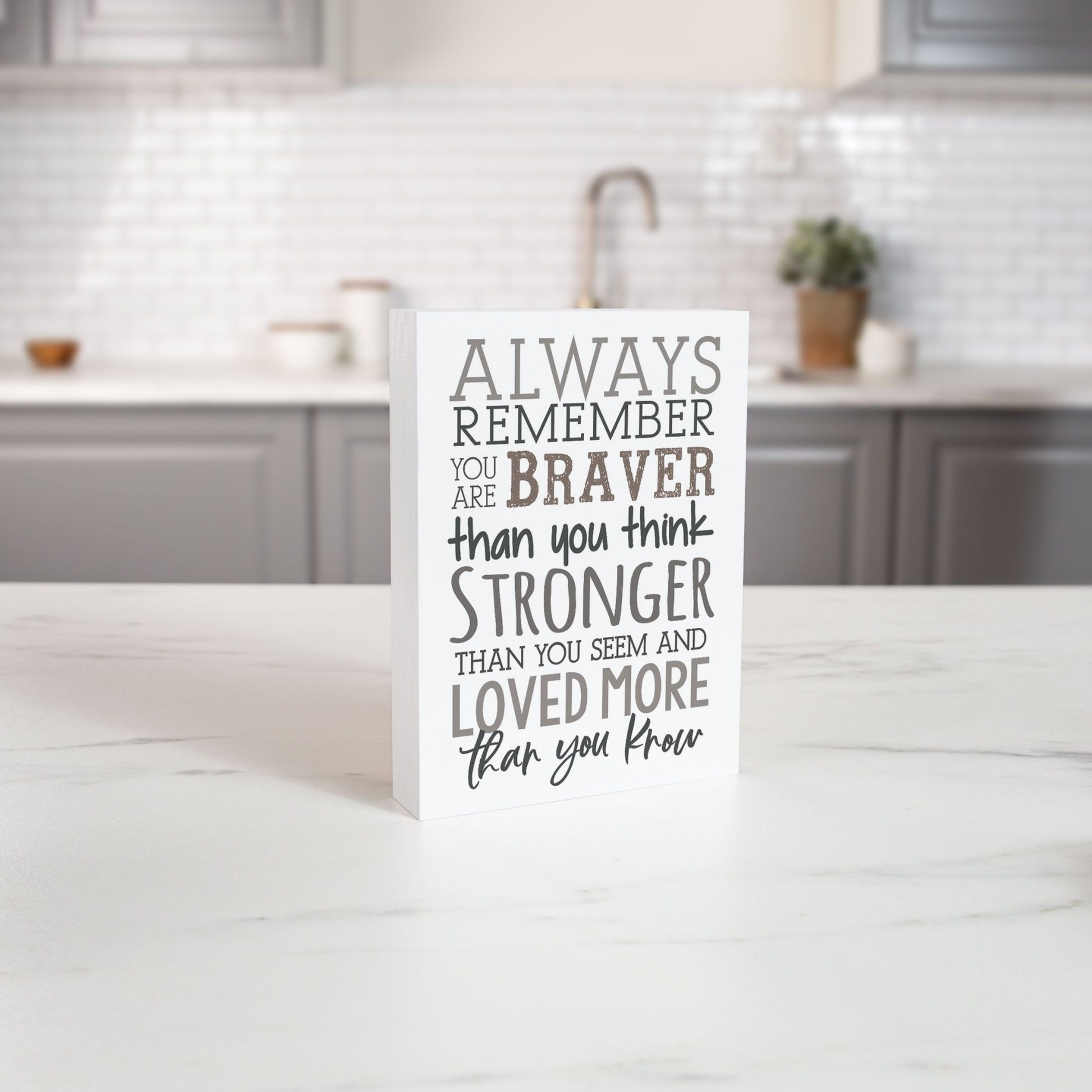 Inspirational Wood Block - Always Remember You are Braver, Stronger, Loved More Than You Know on White Kitchen Counter in front of Grey Kitchen Cabinets | InsideOutCatalog.com