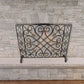 Burnished Gold Gate Design Single Panel Fireplace Screen with Gold Accents in front of stone fireplace | InsideOutCatalog.com