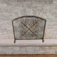 Iron Scroll Design with X in the Center Fire Screen - Single Panel Fireplace Screen with Arched Top in front of stone fireplace | InsideOutCatalog.com