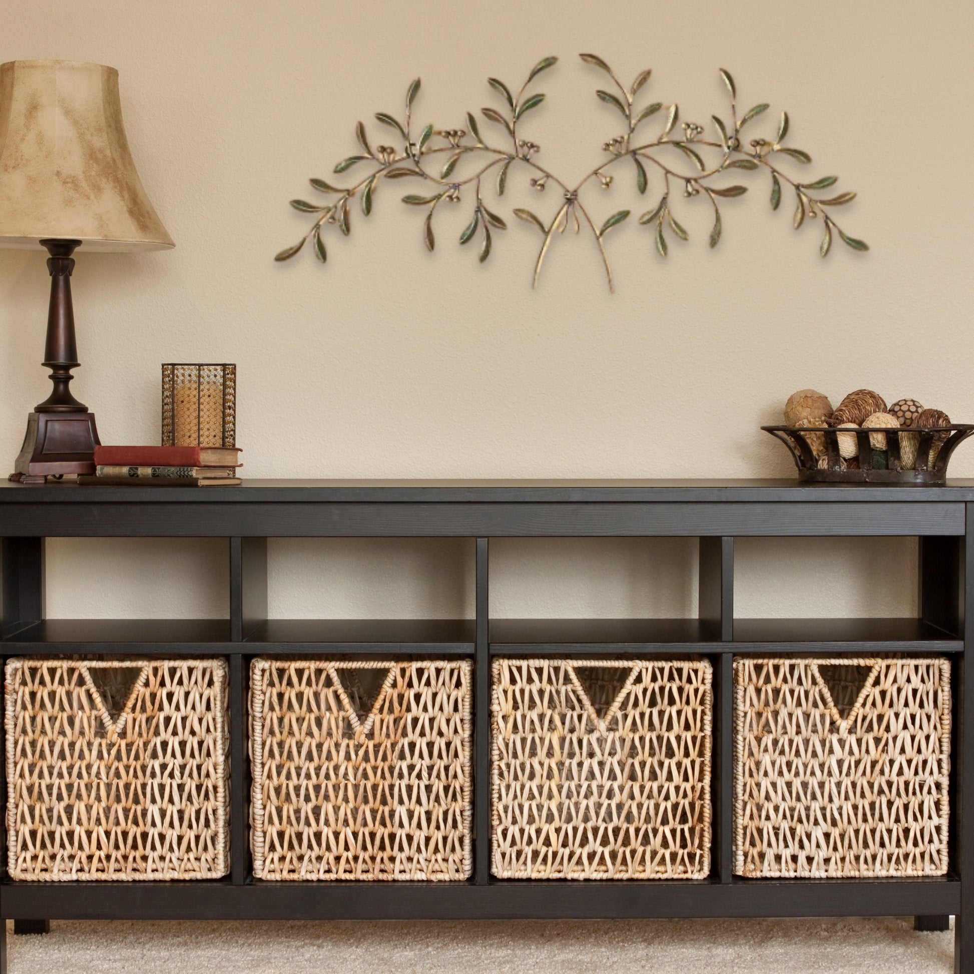 Olive Leaf Iron Wall Grille - Red, Green, Gold Metal Wall Decor above Console table with wicker baskets, lamp, and decorative accents | INSIDE OUT - InsideOutCatalog.com