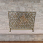Scroll and Leaf Design Single Panel Fireplace Screen in Italian Gold Finish against stone fireplace | InsideOutCatalog.com
