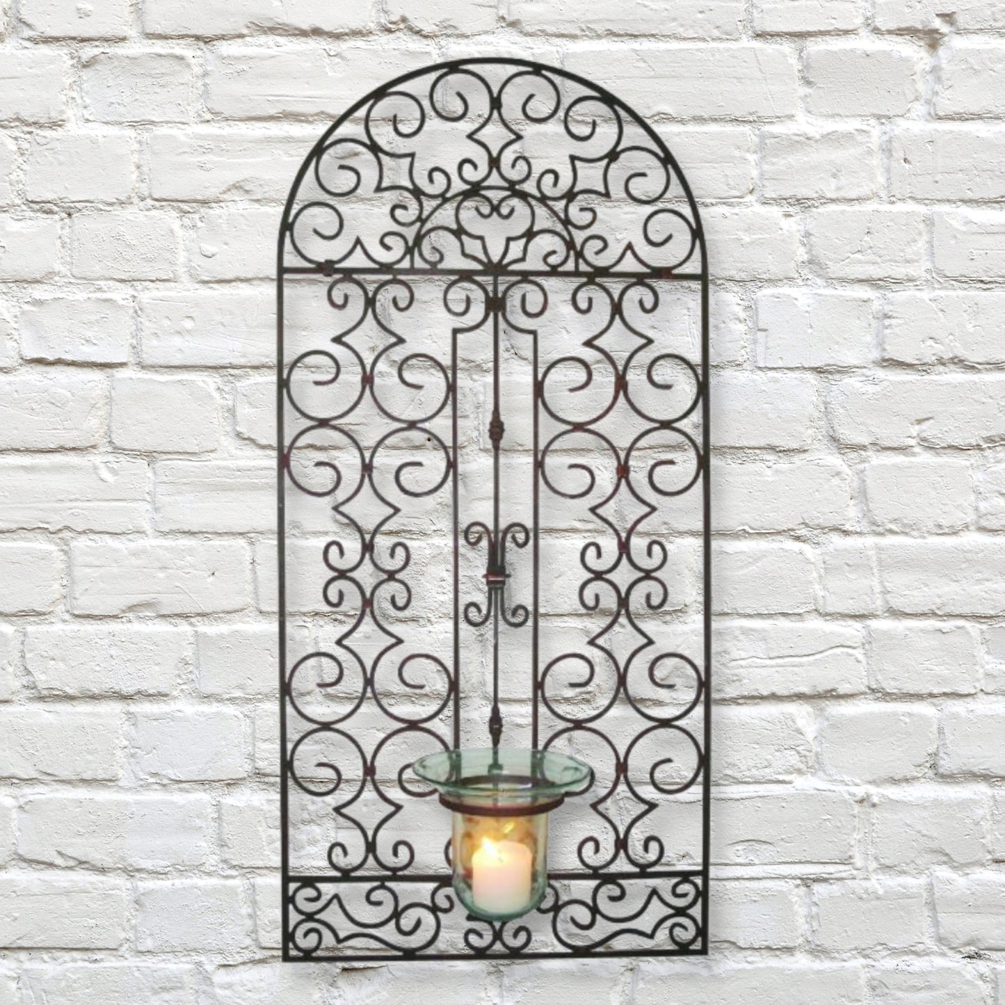 Iron Garden Gate Design Wall Hurricane Candle Holder - Antique Brown Metal Art (49.5"H) shown on a white brick wall | INSIDE OUT | InsideOutCatalog.com