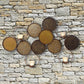 Gold Circle Wall Decor - Four Votive Candle Holder Wall Accent (31"W) shown on a stone wall | InsideOutCatalog.com